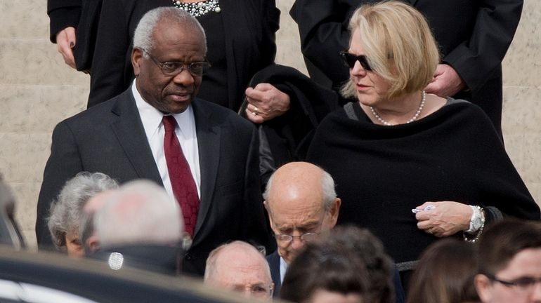 Justice Clarence Thomas, left and his wife, Virginia Thomas, in...