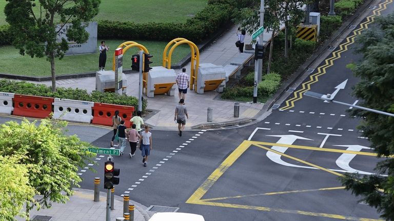 Anti-crash vehicle barriers are seen installed along the pavement outside...