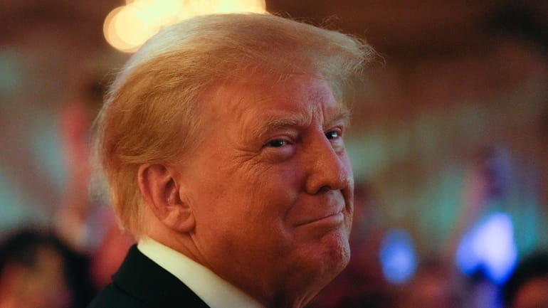 FILE - Former President Donald Trump smiles toward guests, as...