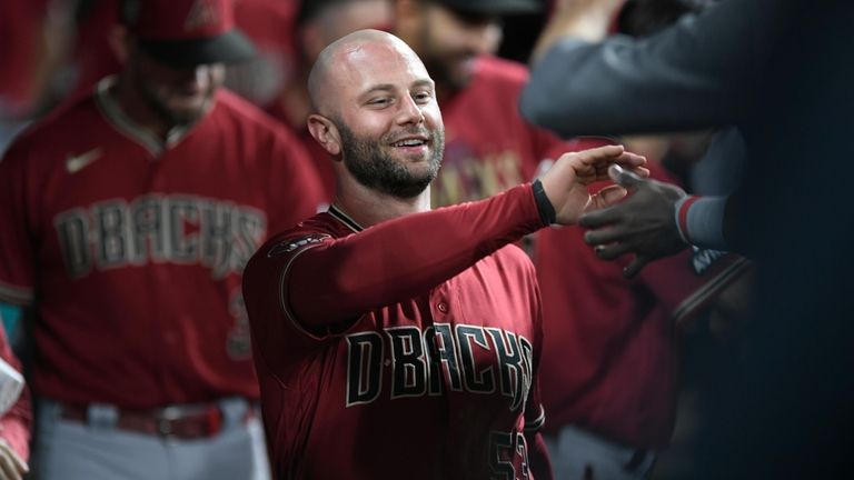 Arizona Diamondbacks' Christian Walker celebrates with teammates in the dugout...