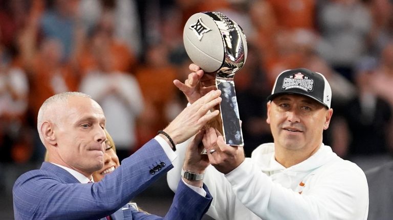 Big 12 Commissioner Brett Yormark, left, presents the trophy to...