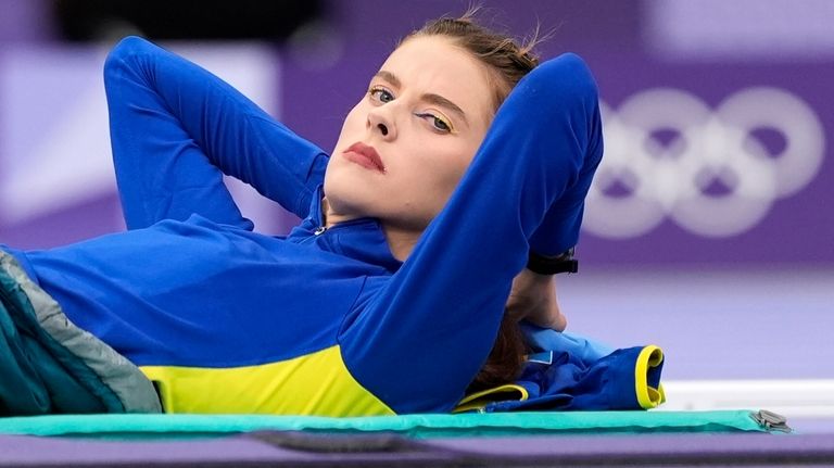 Yaroslava Mahuchikh, of Ukraine, rests before competing in the women's...