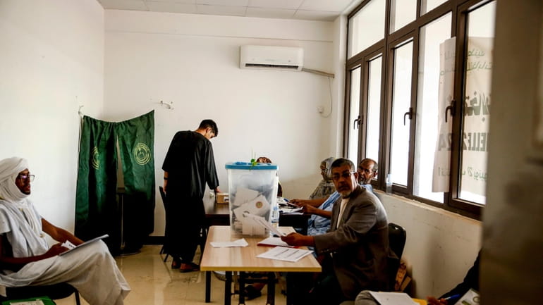 A man casts his ballot, during the presidential election, in...