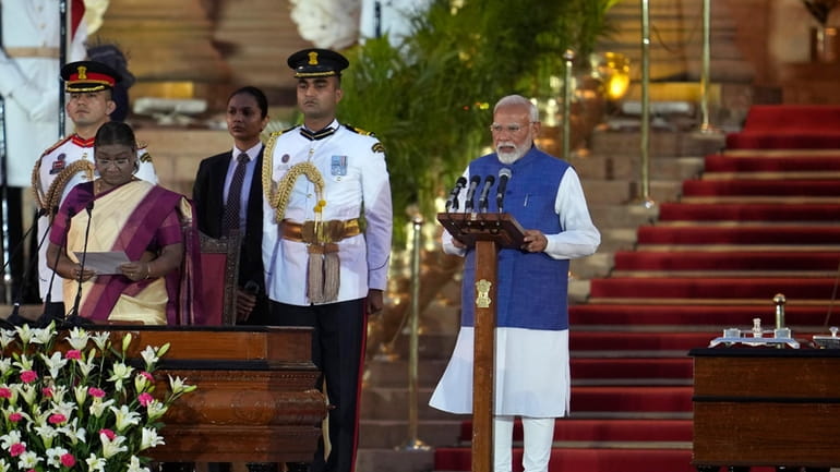Narendra Modi, right, is sworn-in as the Prime Minister of...