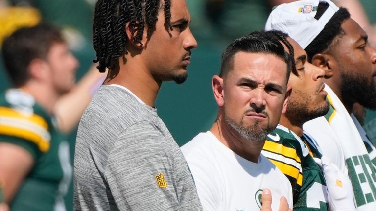 Injured Green Bay Packers quarterback Jordan Love, left, stands with...