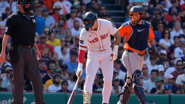 Boston Red Sox's Jarren Duran puts his bat down beside...