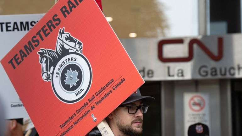 Rail workers picket in front of Canadian National headquarters on...