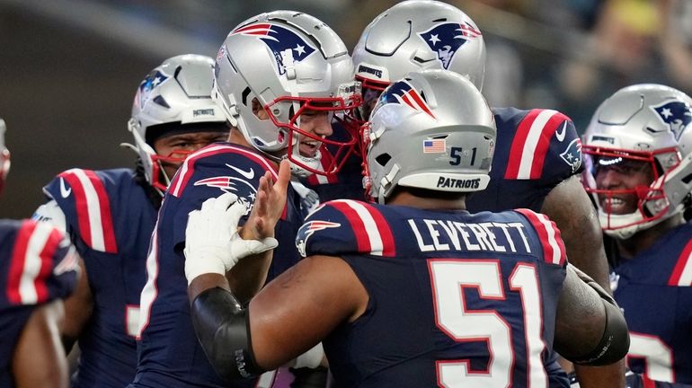 New England Patriots quarterback Drake Maye, center left, celebrates his...