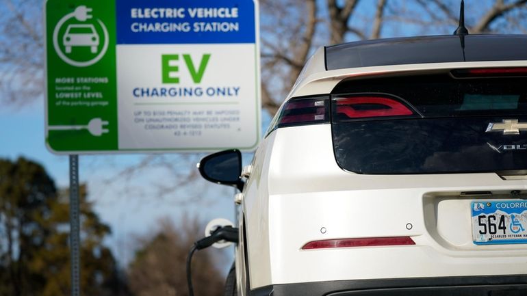 A Chevrolet Volt charges at at a station outside the...