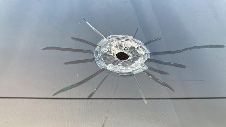 A bullet hole is visible in the glass transom over...