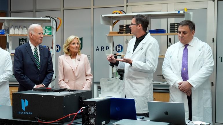 President Joe Biden and first lady Jill Biden listen during...