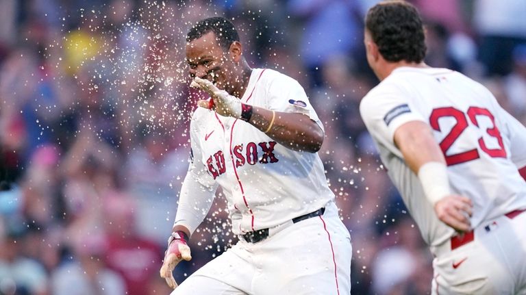 Boston Red Sox's Rafael Devers, left, celebrates after his game-winning...