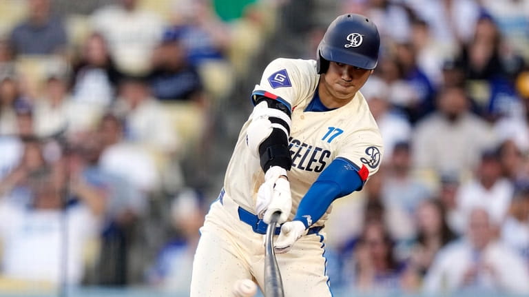 Los Angeles Dodgers designated hitter Shohei Ohtani lines out during...