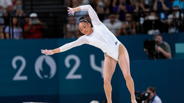 Suni Lee, of the United States, bobbles and falls during...