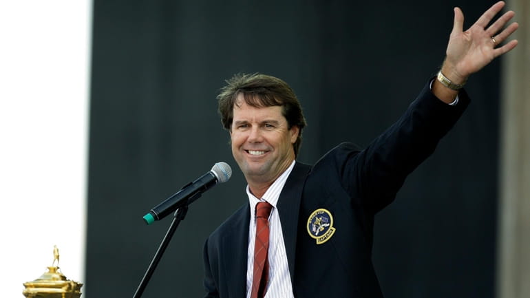 United States team captain Paul Azinger waves to spectators while...