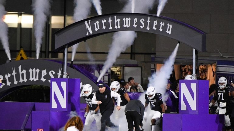 Northwestern head football coach David Braun, third from left, leads...