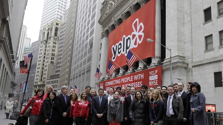 Executives, employees and guests of Yelp pose for photos in...
