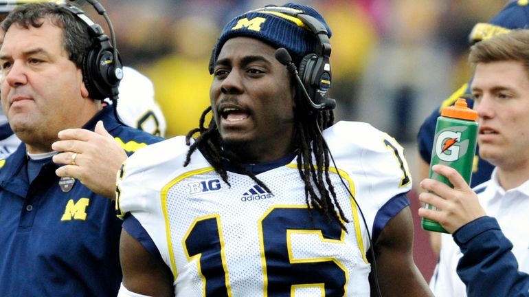 Michigan head coach Brady Hoke, left, and quarterback Denard Robinson,...