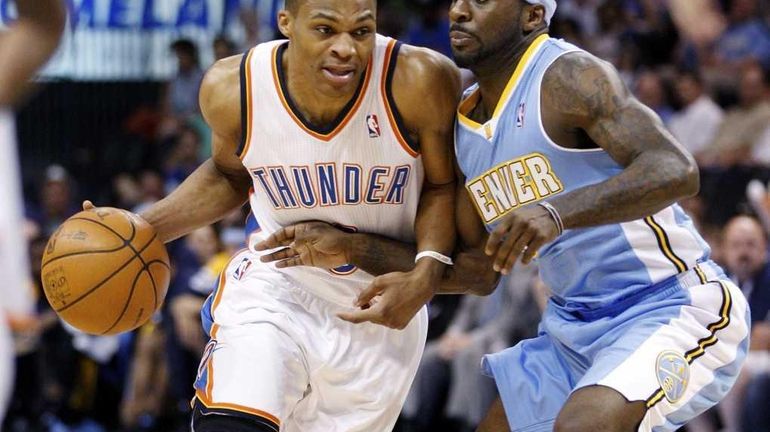 Oklahoma City Thunder guard Russell Westbrook, left, drives around Denver...