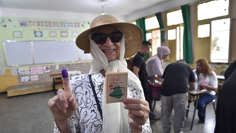 A voter poses for a photo with her inked finger...