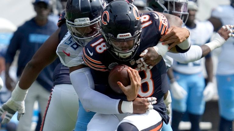 Tennessee Titans linebacker Harold Landry III, left, sacks Chicago Bears...