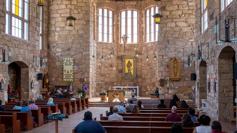 Mescalero Apache Tribe members and parishioners attend Mass at the...