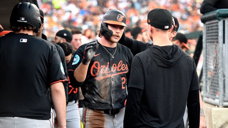 Baltimore Orioles' Gunnar Henderson, middle, is congratulated by teammates in...