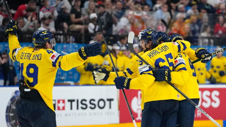 Sweden's Erik Karlsson celebrates with teammates after scoring his sides...