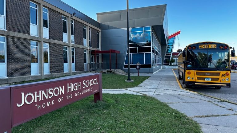 A school bus sits outside Johnson Senior High School in...