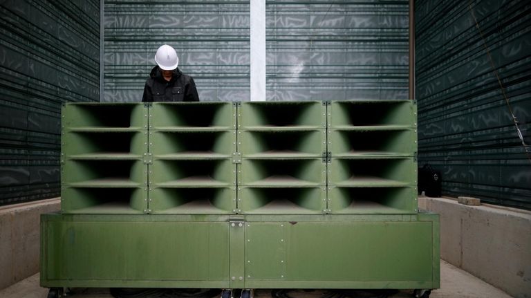 A worker dismantles loudspeakers that set up for propaganda broadcasts...