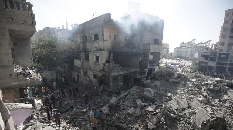 Palestinians look at the aftermath of the Israeli bombing in...