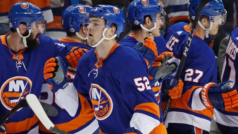 Islanders left wing Ross Johnston greets teammates after scoring a...