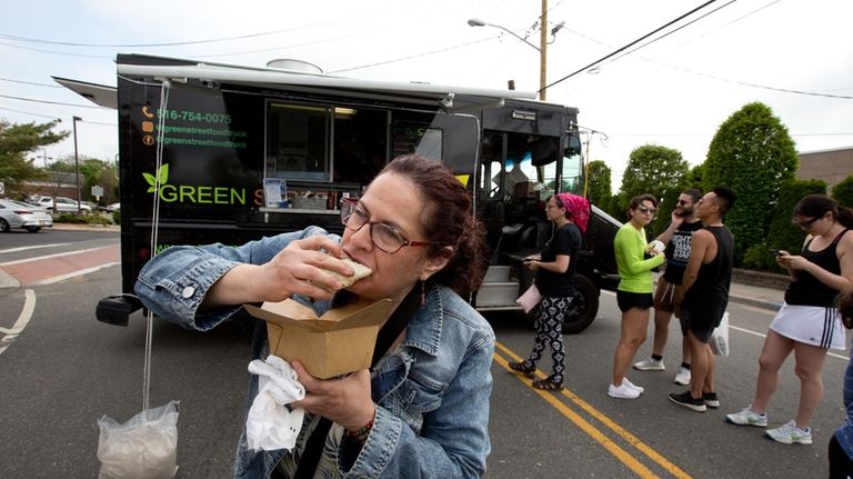 Tami Racaniello, of Huntington, eats a taco at the Green...