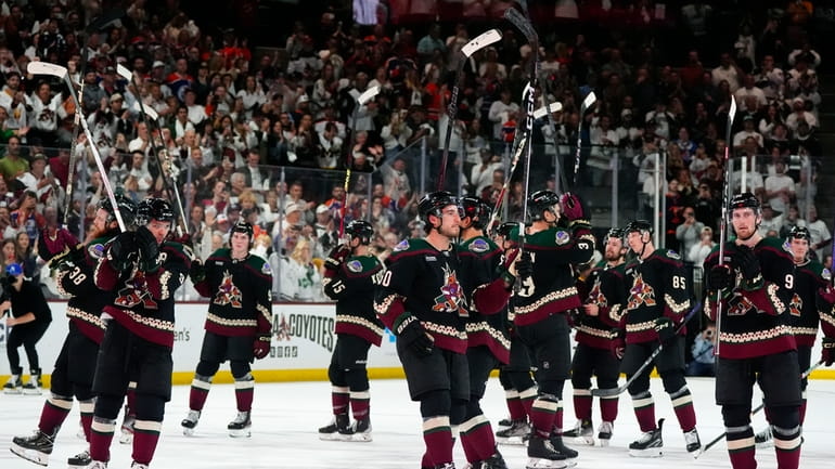 Arizona Coyotes players acknowledge the fans after an NHL hockey...