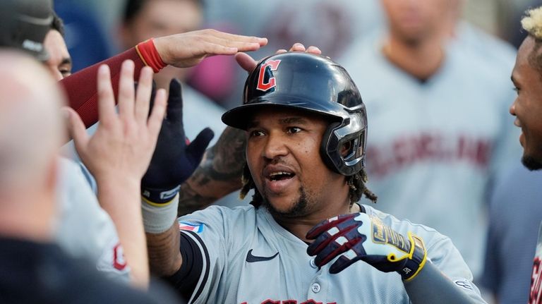 Cleveland Guardians' Jose Ramírez is greeted in the dugout after...