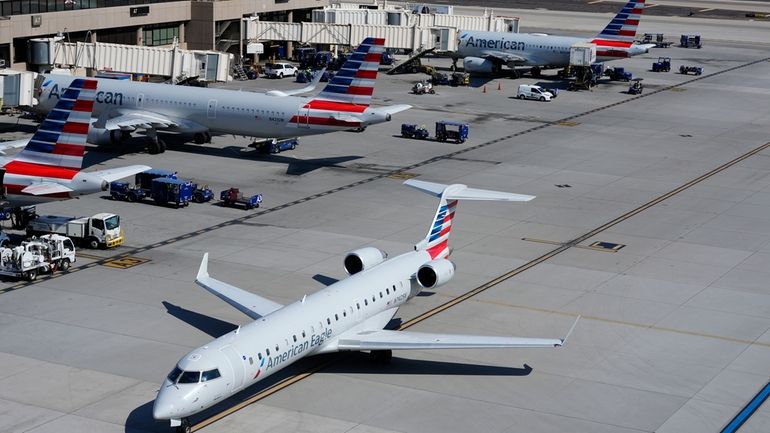 American Airlines planes wait at gates at Phoenix Sky Harbor...