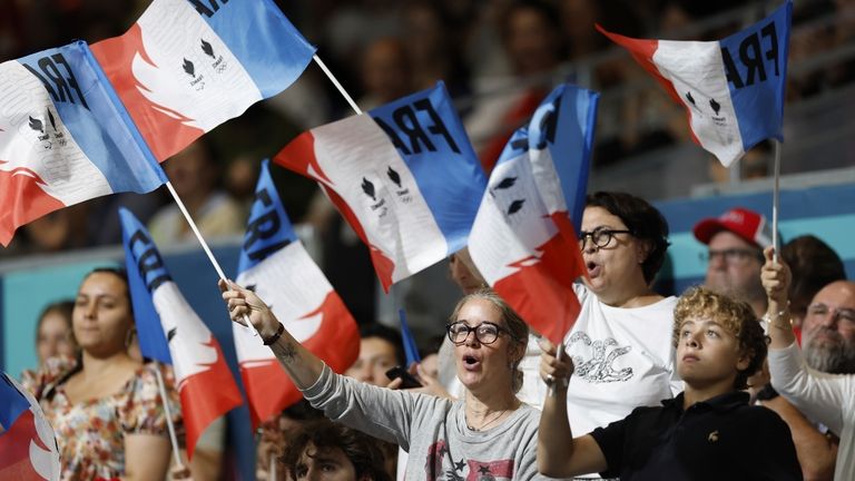 Event attendees cheer while waving French flags during the mens'...