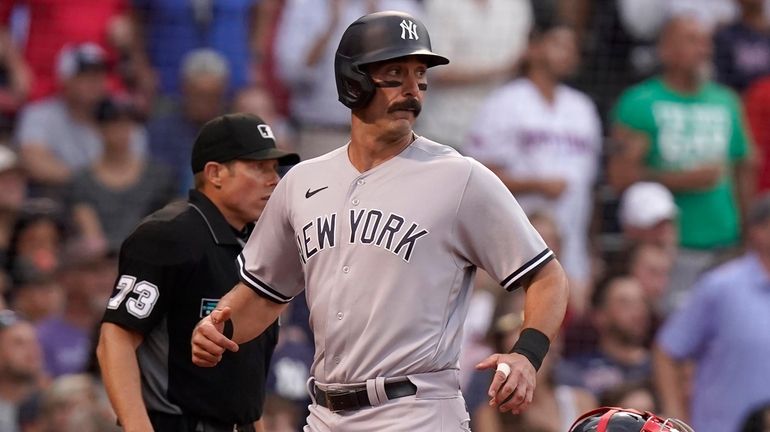 The Yankees' Matt Carpenter, center, scores on a single by...