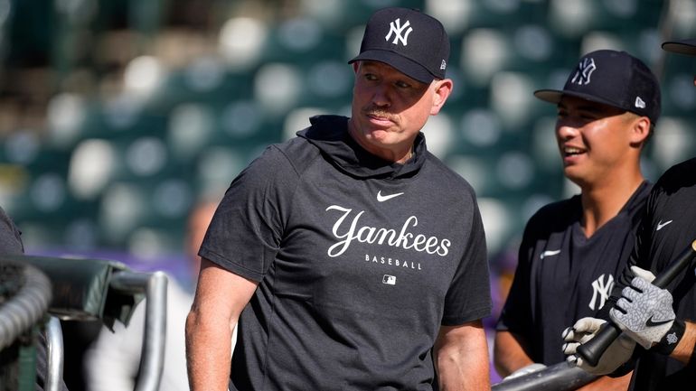 Yankees hitting coach Sean Casey watches players warm up for...