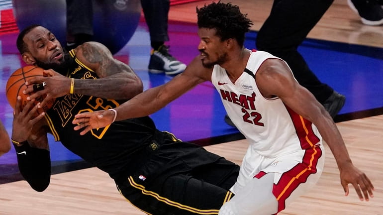Lakers forward LeBron James pulls a rebound away from Heat...