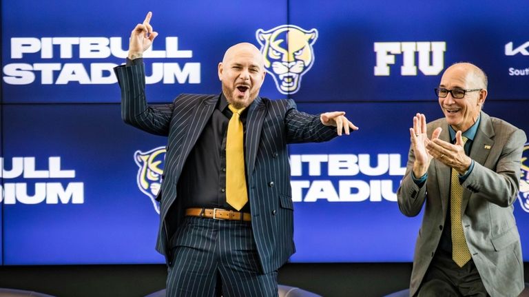 Cuban-American recording artist Pitbull, left, appears at a press conference...