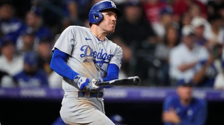 Los Angeles Dodgers' Freddie Freeman watches his three-run home run...