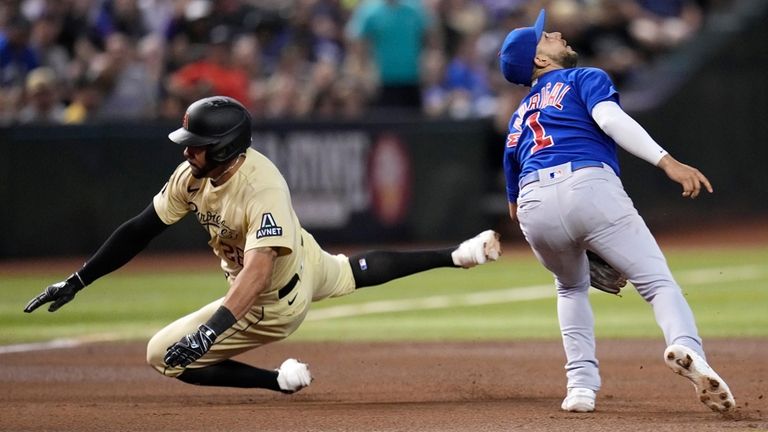 Arizona Diamondbacks' Tommy Pham, left, dives around Chicago Cubs third...