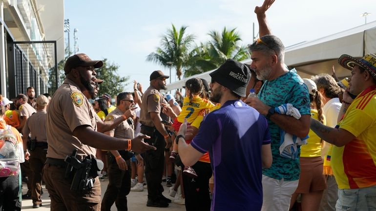 Policemen talk with fans outside the stadium prior to the...