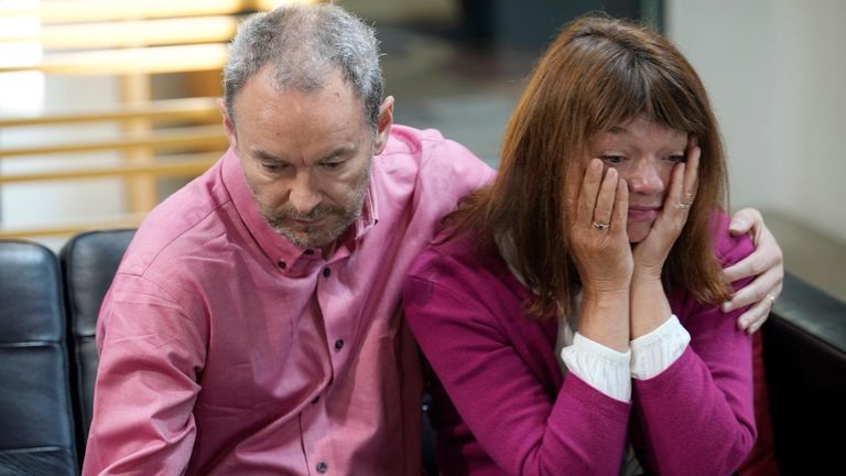 Simon Glass, left, and his wife, Sally Glass, embrace as...