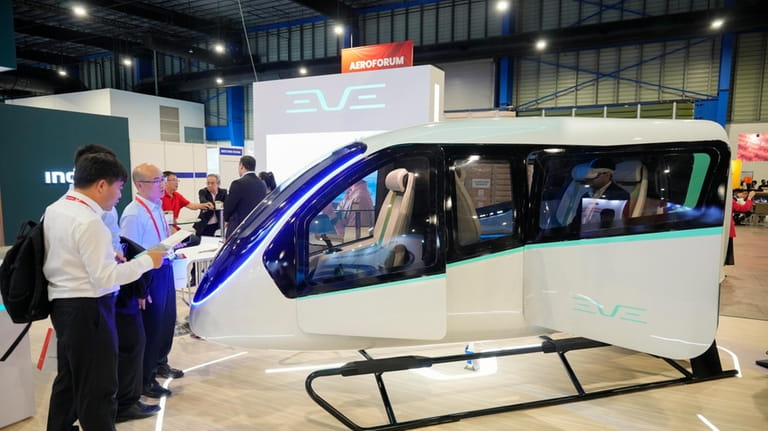 Visitors look at Brazilian firm Eve Air Mobility, a spin-off...