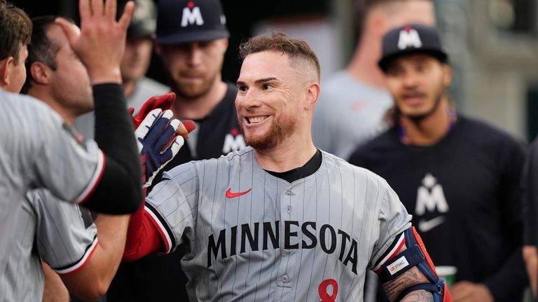 Minnesota Twins' Christian Vazquez is greeted in the dugout after...