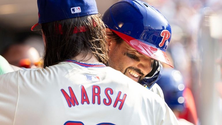 Philadelphia Phillies' Nick Castellanos, right, is congratulated by Brandon Marsh,...