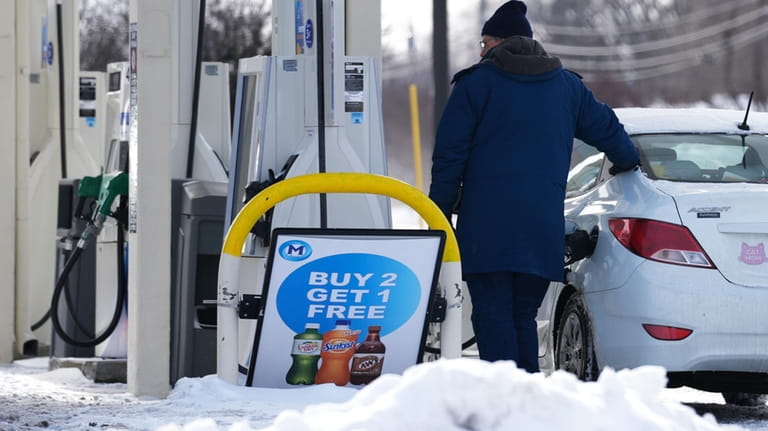 A customer pumps gas at a gas station in Wheeling,...