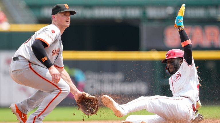 Cincinnati Reds' Elly De La Cruz, right, steals third base...